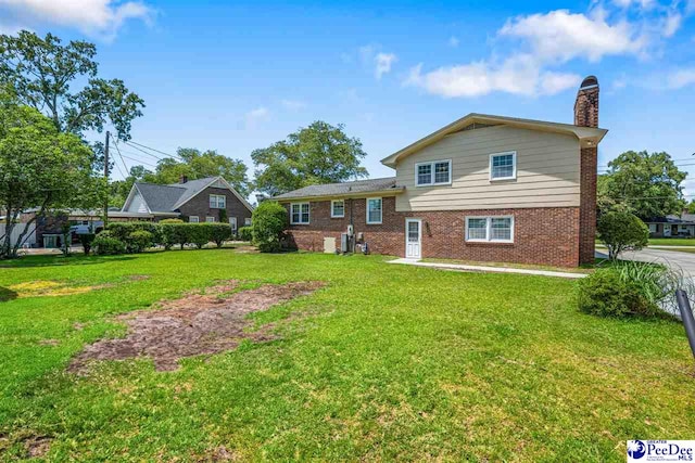908 Clarendon Ave, Florence, SC 29505 - back of house with a chimney, a lawn, and brick siding