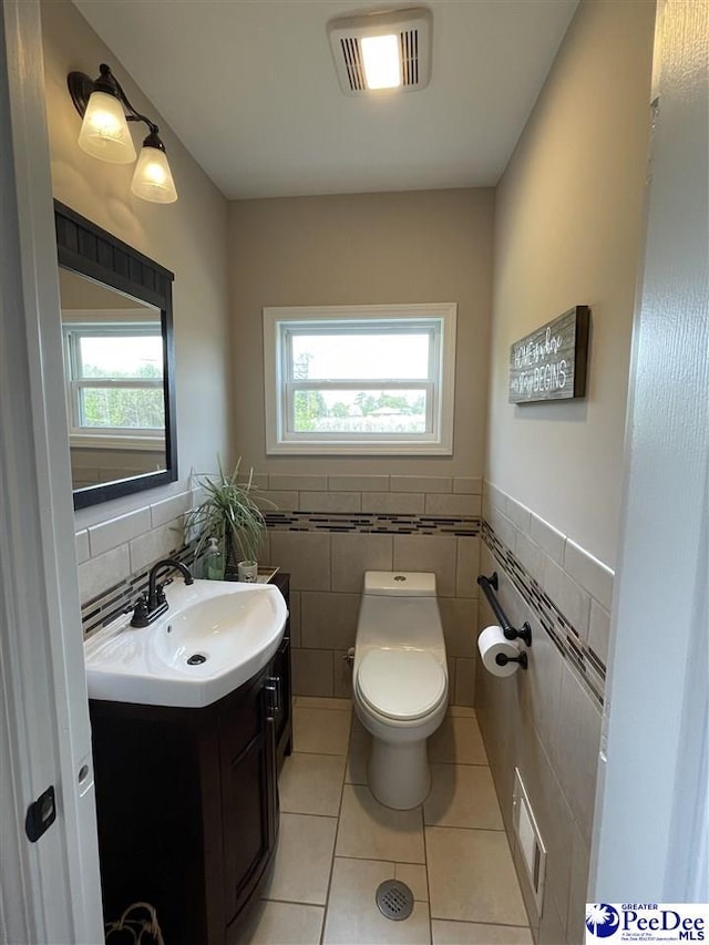 1429 E Home Ave, Hartsville, SC 29550 - half bathroom featuring vanity, tile patterned floors, toilet, plenty of natural light, and tile walls