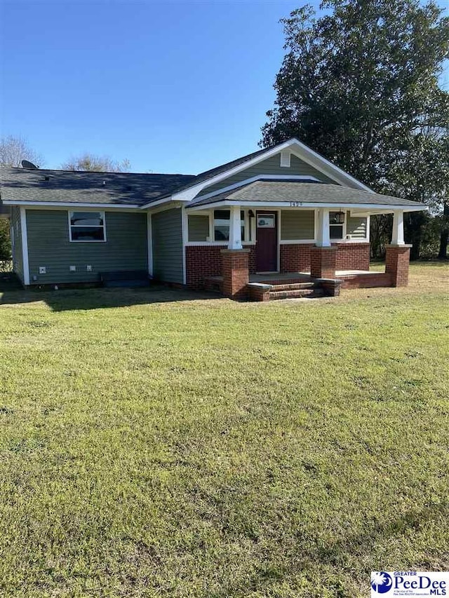 1429 E Home Ave, Hartsville, SC 29550 - craftsman-style home with covered porch, a front yard, brick siding, and a shingled roof
