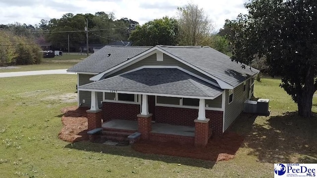 1429 E Home Ave, Hartsville, SC 29550 - exterior space featuring covered porch, a lawn, a shingled roof, and central AC unit
