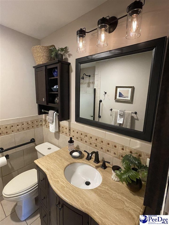 1429 E Home Ave, Hartsville, SC 29550 - bathroom featuring toilet, vanity, tile patterned flooring, tile walls, and a wainscoted wall