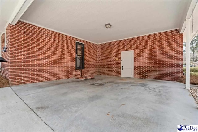 exterior space with brick wall and unfinished concrete floors