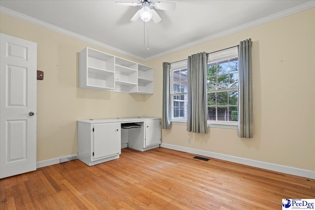 unfurnished office with ornamental molding, light wood-style flooring, visible vents, and baseboards