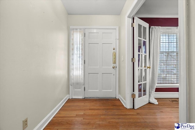 entrance foyer with baseboards, visible vents, and wood finished floors