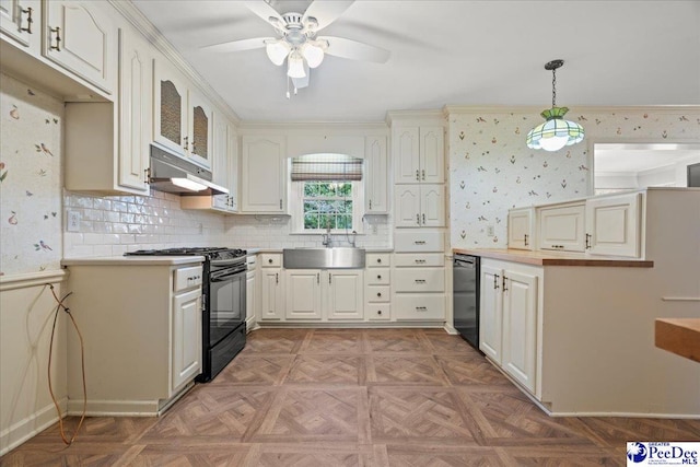 kitchen featuring decorative light fixtures, black gas range, a sink, under cabinet range hood, and wallpapered walls