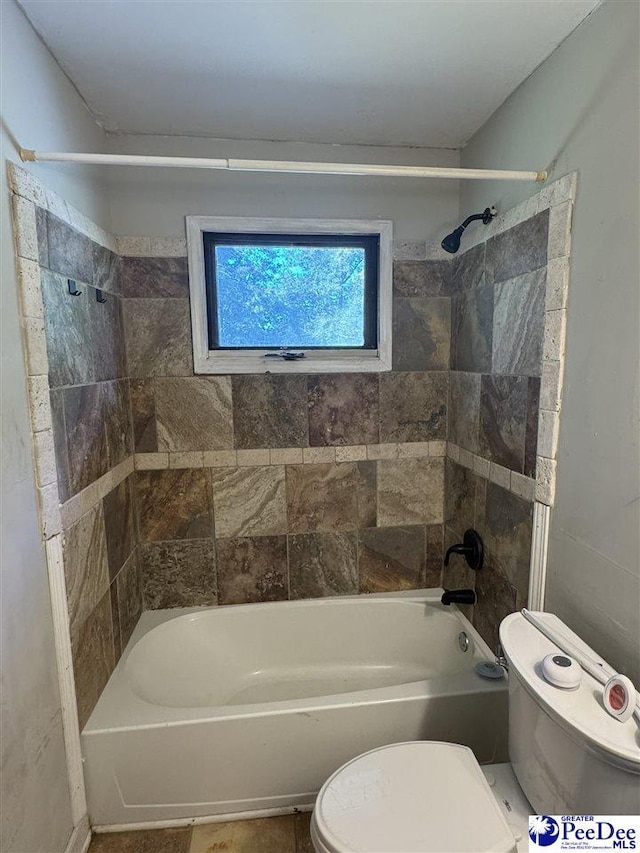 bathroom with toilet and tiled shower / bath