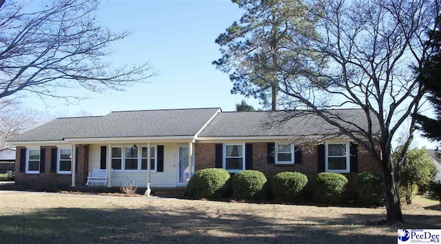 single story home with a shingled roof and brick siding