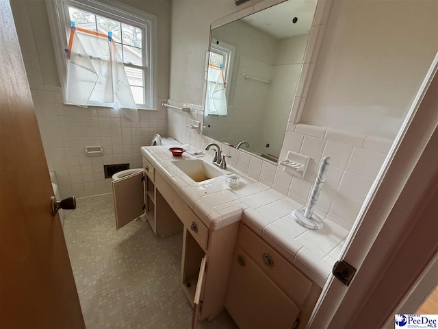 bathroom featuring a wainscoted wall, tile walls, toilet, vanity, and tile patterned floors