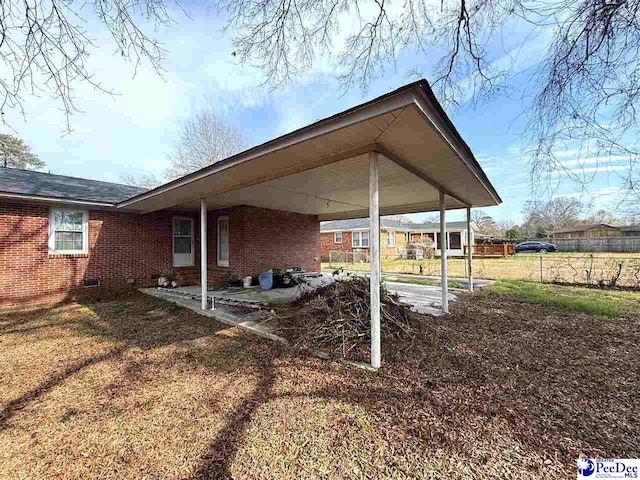 exterior space featuring a carport and fence