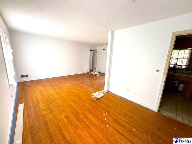 interior space featuring visible vents, baseboards, and wood finished floors