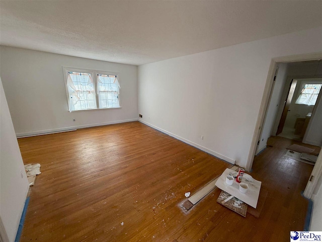 spare room with wood finished floors and baseboards