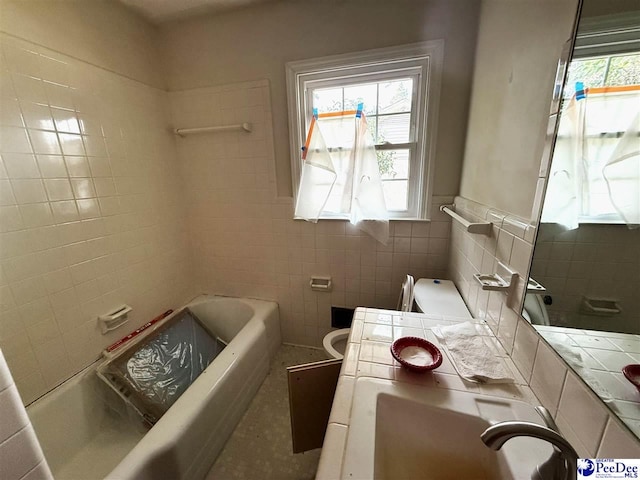 full bathroom with toilet, a wainscoted wall, vanity, tile walls, and  shower combination