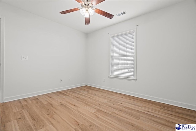 empty room featuring ceiling fan, light wood-type flooring, visible vents, and baseboards