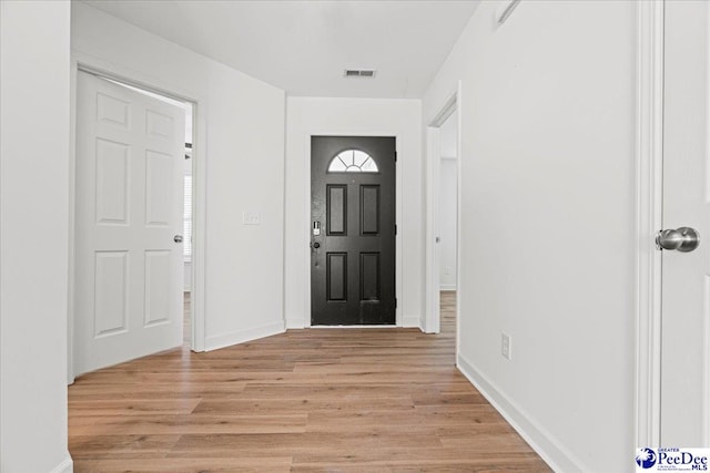 entryway featuring light wood finished floors, baseboards, and visible vents