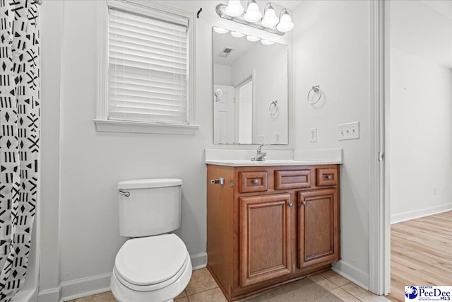 bathroom featuring a shower with shower curtain, vanity, toilet, and tile patterned floors