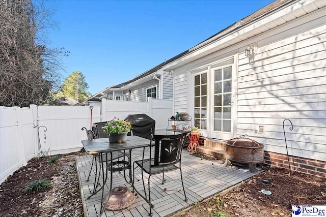 view of patio / terrace featuring a fenced backyard, a fire pit, grilling area, and outdoor dining space