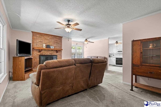 carpeted living room featuring a textured ceiling, ceiling fan, ornamental molding, and a fireplace