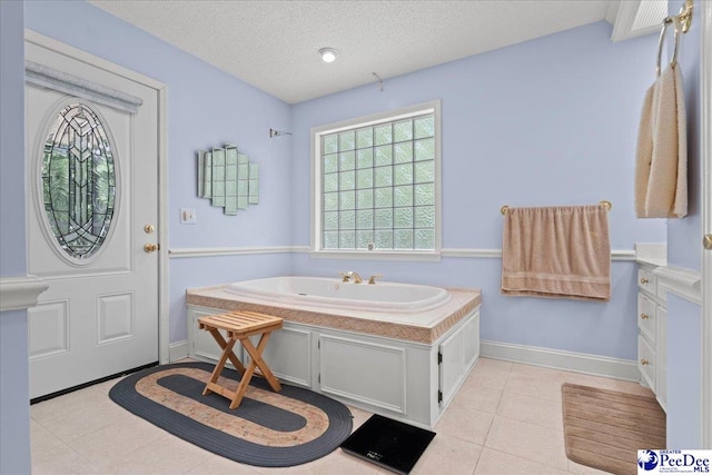 full bathroom with baseboards, tile patterned floors, a textured ceiling, and a bath