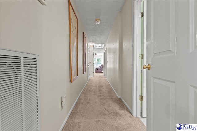 corridor with carpet flooring, a textured ceiling, baseboards, and a heating unit