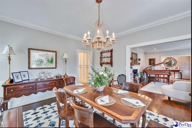 dining area with a notable chandelier, hardwood / wood-style flooring, and ornamental molding