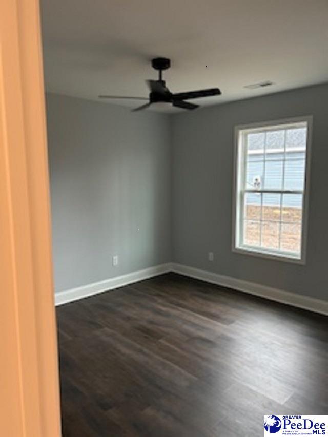 empty room with dark wood-type flooring and ceiling fan