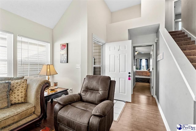 sitting room featuring a healthy amount of sunlight, high vaulted ceiling, and light wood-type flooring