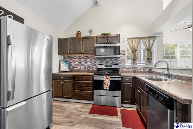 kitchen with sink, light wood-type flooring, appliances with stainless steel finishes, ceiling fan, and decorative backsplash