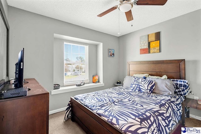 bedroom featuring ceiling fan, carpet floors, and a textured ceiling