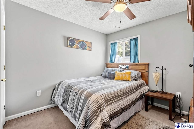 carpeted bedroom featuring ceiling fan and a textured ceiling