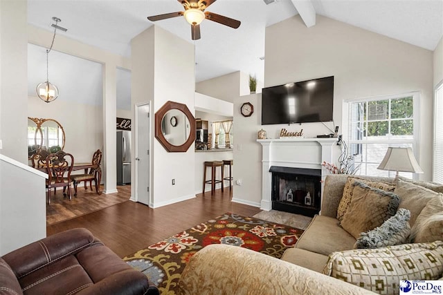 living room with ceiling fan with notable chandelier, dark hardwood / wood-style floors, high vaulted ceiling, and beam ceiling