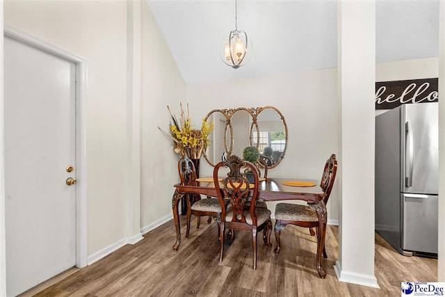 dining space featuring hardwood / wood-style flooring and vaulted ceiling