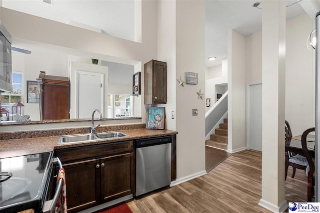 kitchen with hardwood / wood-style floors, sink, stainless steel dishwasher, electric range, and dark brown cabinets