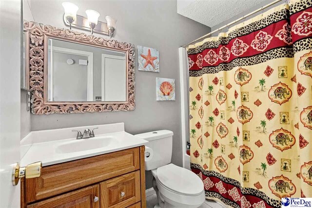 bathroom featuring vanity, toilet, and a textured ceiling