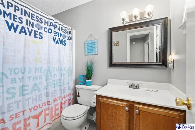 bathroom featuring vanity, a textured ceiling, and toilet