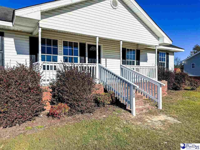 view of front facade with covered porch and a front lawn