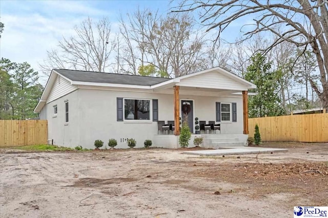 236 Wells St, Lake City, SC 29560 - view of front of home with a porch, fence, and stucco siding