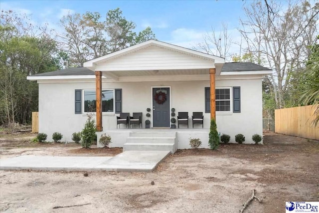 236 Wells St, Lake City, SC 29560 - view of front of home with stucco siding, a porch, and fence