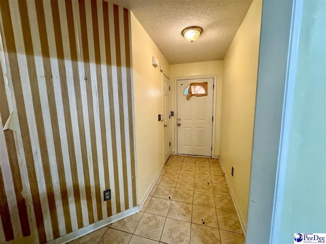 entryway with light tile patterned floors and a textured ceiling