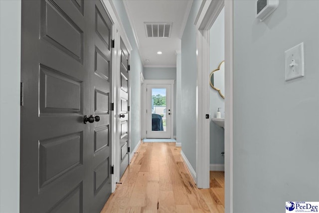 hallway with crown molding, light wood-type flooring, baseboards, and recessed lighting