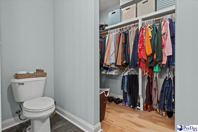 bathroom featuring baseboards, toilet, and wood finished floors