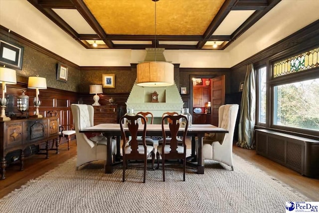 dining space with beamed ceiling, coffered ceiling, and radiator