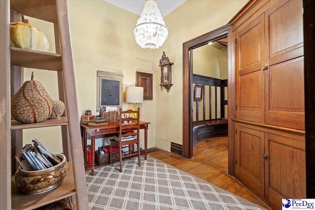 corridor featuring light hardwood / wood-style floors and a notable chandelier