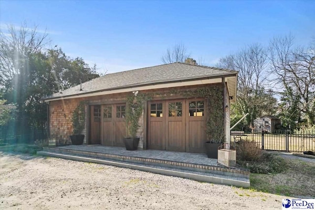 view of front of property featuring a garage and an outbuilding