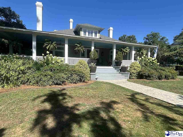 view of front of property featuring covered porch and a front yard