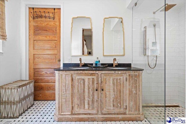 bathroom with tiled shower and vanity