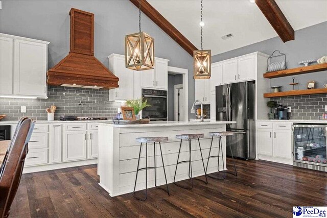 kitchen featuring decorative backsplash, beam ceiling, black appliances, wine cooler, and custom range hood