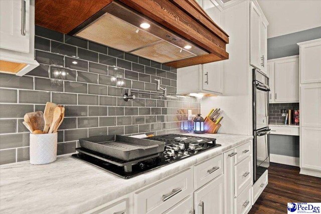 kitchen with dark wood-style floors, light countertops, white cabinetry, tasteful backsplash, and black appliances