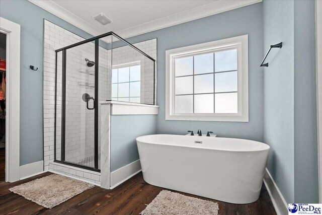 full bath featuring a freestanding bath, ornamental molding, a stall shower, and wood finished floors