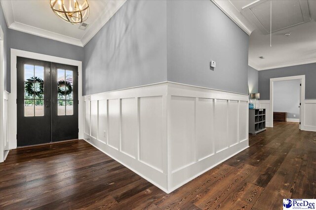 foyer entrance with wood-type flooring, french doors, and a decorative wall