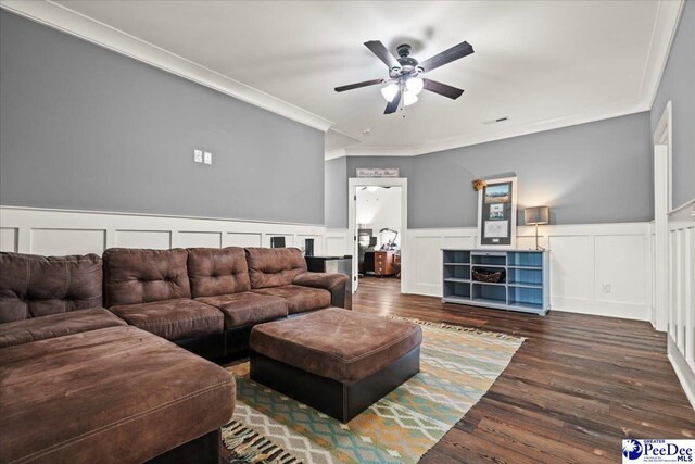 living area with ornamental molding, wainscoting, a ceiling fan, and a decorative wall